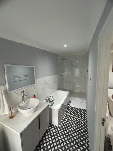 a bathroom with a sink and a bath tub and a sink at 13 on Newington in Gqeberha