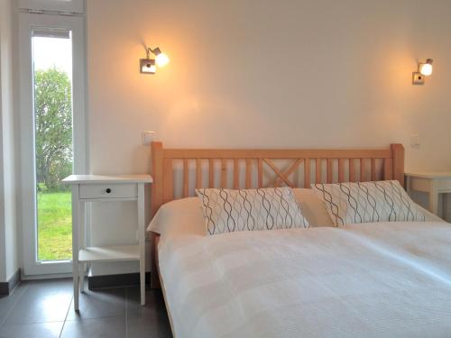 a bedroom with a bed and a window at Badeuferhaus in Hestoft