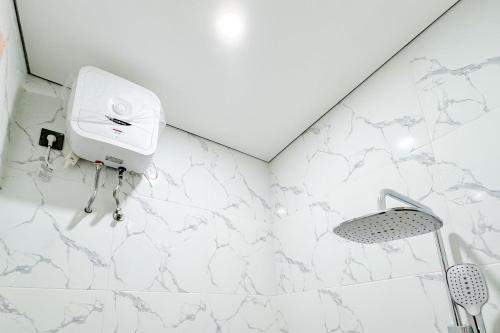 a bathroom with a white marble wall at Urbanview Hidayah Living Syariah Balekambang Manahan in Bonorejo