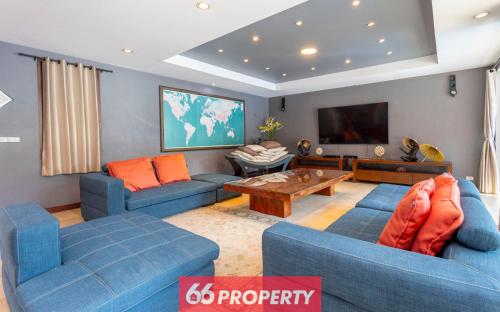 a living room with blue couches and a flat screen tv at THE ONE VILLA in Chiang Mai