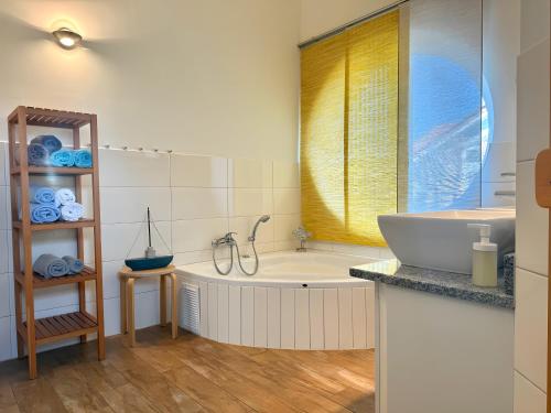 a bathroom with a tub and a sink at Rosenuferhaus in Hestoft