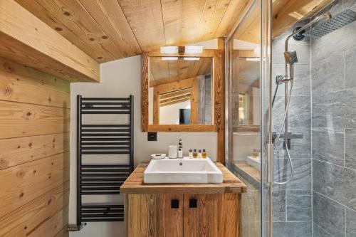 a bathroom with a sink and a shower at Chalet Ysalpe - Vue montagne hammam sauna jacuzzi et salle cinéma in Megève