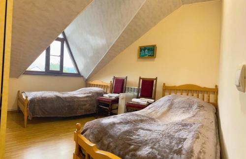 a attic room with two beds and a window at Bella Vista in Dilijan