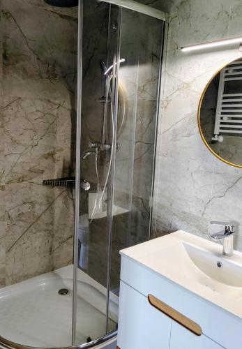 a bathroom with a shower and a sink at Apartamenty Jodłowa in Suwałki
