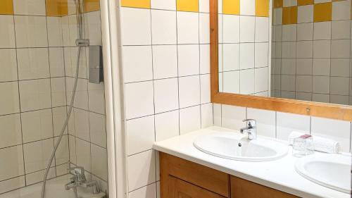 une salle de bain avec un lavabo, un miroir et une douche dans l'établissement Villages Clubs du Soleil - VALMOREL, à Valmorel
