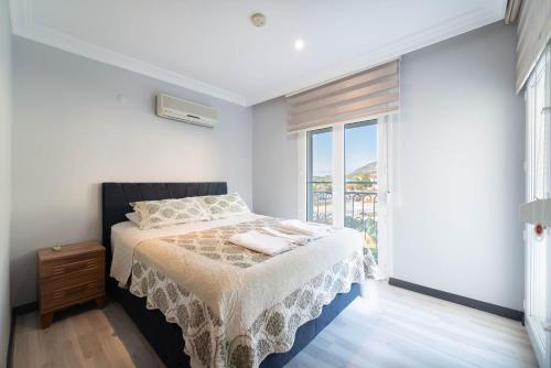 a bedroom with a bed and a large window at Villa Tara in Ovacik
