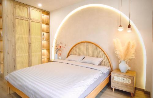 ein Schlafzimmer mit einem großen Bett mit einem Bogen darüber in der Unterkunft Mei Villa - Ocean Park 3 in Ðình Loan