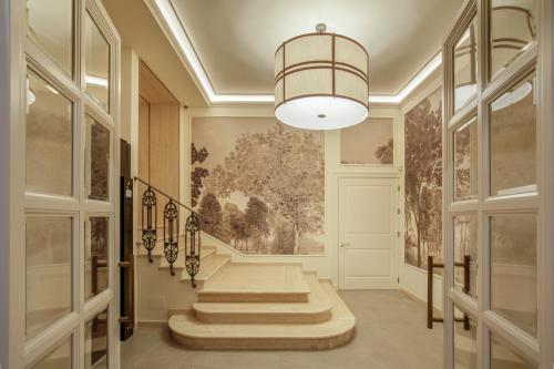 a hallway with stairs and a chandelier at Villa Miliani in Fabriano