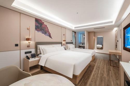 a hotel room with two beds and a television at Elong Hotel Beijing Chang'an Tianjie Bridge Huiying Metro Station Branch in Beijing