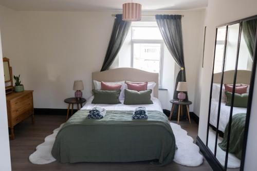 a bedroom with a bed and a mirror at THE LOFT Alnmouth in Alnmouth