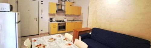 a kitchen with yellow cabinets and a blue couch at Eli's House in Bardolino sul Garda in Bardolino