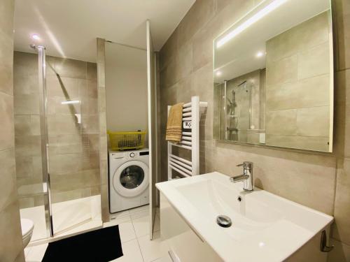 a bathroom with a sink and a washing machine at Maison proche de la mer in Sainte-Marie-la-Mer