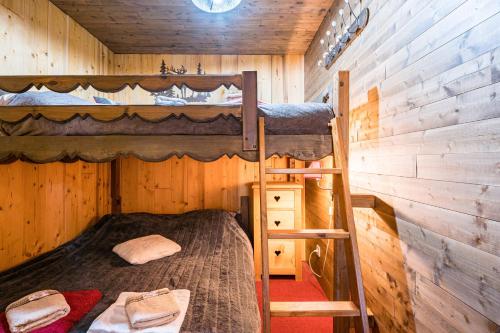 a bedroom with two bunk beds in a wooden cabin at Bas De Chalet Lout'Chi Valfréjus in Valfréjus