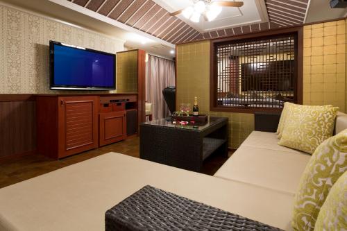 a living room with a couch and a flat screen tv at ホテルウォーターゲート岡山 in Okayama