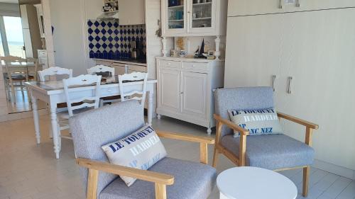 a kitchen with two chairs and a table with a dining room at Joli studio Hardelot face mer, à 100m du centre-ville! in Hardelot-Plage