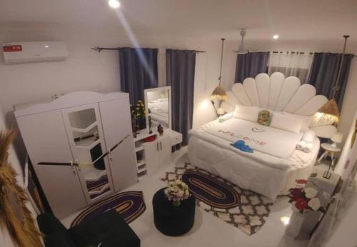 a small bedroom with a bed and a refrigerator at Malaika White House Apartment & Spa in Kiwengwa