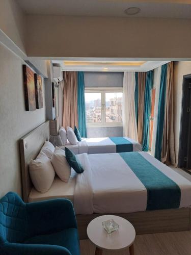 a hotel room with two beds and a window at Mar Charbel Hotel Cairo in Cairo