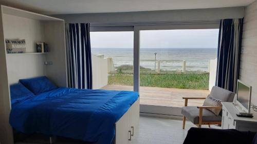 a bedroom with a bed and a view of the ocean at Joli studio Hardelot face mer, à 100m du centre-ville! in Hardelot-Plage