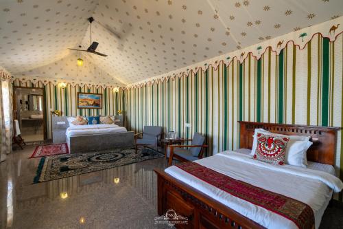 a bedroom with two beds and a couch and a table at NK Desert Camp Jaisalmer in Sām