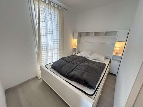 a bed in a white room with a window at Appt Studio 2 couchages CAP D'AGDE CT121-022 in Cap d'Agde