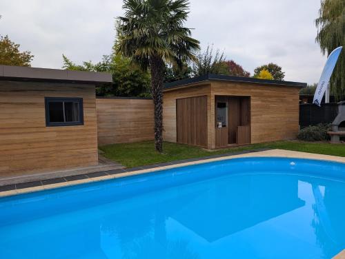 a house with a swimming pool next to a building at NUVOLA VILLA in Zottegem