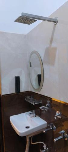 a bathroom with a white sink and a mirror at Hotel Prince palace in Ayodhya