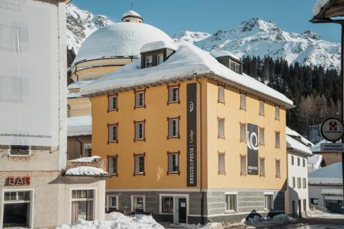 a yellow building with a snow covered roof at Lodge Brocco & Posta in San Bernardino