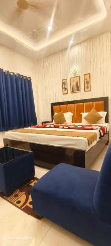 a bedroom with a large bed with blue curtains at Hotel Prince palace in Ayodhya