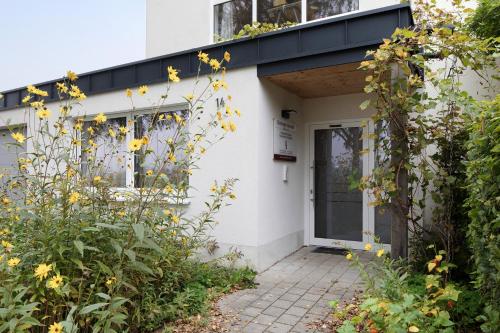 a white house with yellow flowers in front of it at Ferienwohnung Tuniberg in Umkirch