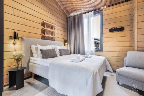 a hotel room with a bed and a chair at Levin Lyhty Bea by Hilla Villas in Kittilä