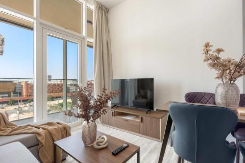 sala de estar con ventana grande y TV en Silkhaus Deluxe 1BR in Masdar City at Oasis, en Abu Dhabi Intl