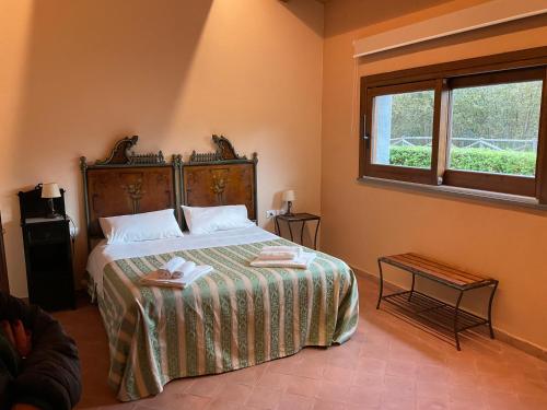 une chambre avec un grand lit et une fenêtre dans l'établissement Feudo Magazzeni Etna, à SantʼAlfio
