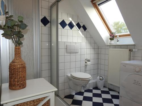 a bathroom with a toilet and a window at Ferienwohnung MeerMoment in Wangerland