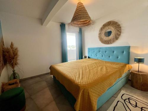une chambre avec un lit bleu et un miroir dans l'établissement Appartement Standing 3 pièces CAP D 'AGDE CT037-053, au Cap d'Agde