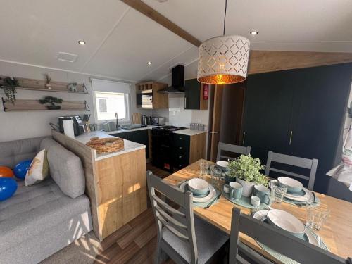 a kitchen and dining room with a table and a couch at Fantasy Island - Eastgate E6 - The Sierra with Hot Tub - Coastal Caravan Breaks in Ingoldmells
