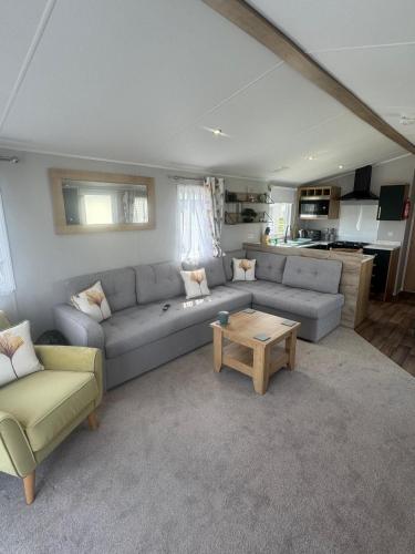 a living room with a couch and a table at Fantasy Island - Eastgate E6 - The Sierra with Hot Tub - Coastal Caravan Breaks in Ingoldmells