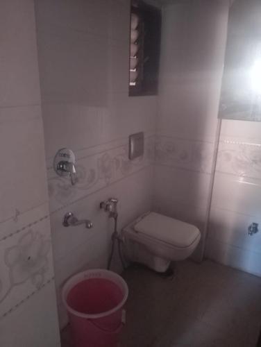 a bathroom with a toilet and a trash can at Lakeside in Mumbai