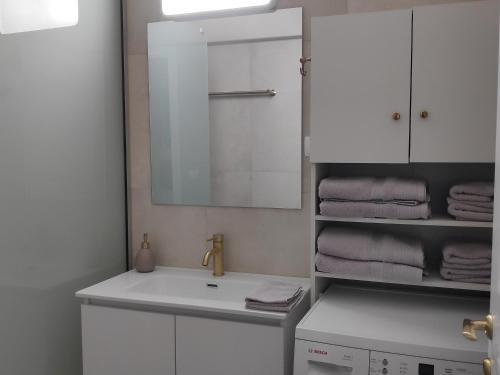 a bathroom with a sink and a mirror and towels at Parginaki House in Parga