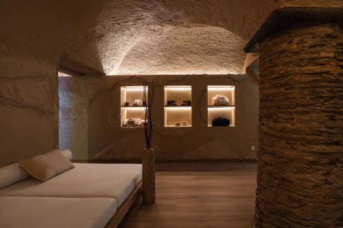 a room with a couch and a stone wall at Hotel Brocco & Posta in San Bernardino