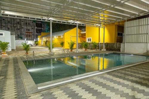 蓬蒂切里Le Pon Villa的一栋黄色建筑内的游泳池