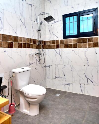 a bathroom with a toilet and a shower at Résidence meublée kribi in Kribi