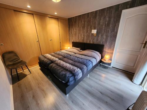a bedroom with a bed and a chair in it at Chalet 42 'Vuursteenberg' Bospark IJsselheide Zwolle Hattemerbroek in Hattemerbroek