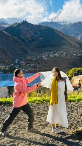 a man and a woman are playing with a kite at Cottage Nishi in Kazbegi