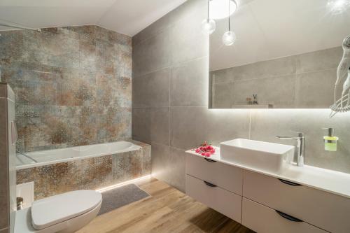 Un baño con inodoro, lavabo y bañera. en Willa Ponikiewka, en Międzybrodzie Bialskie