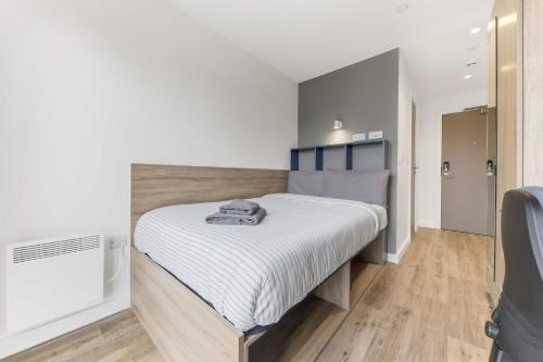 a bedroom with a large bed with white sheets at Brand New Ensuite Rooms In Central Leeds in Leeds