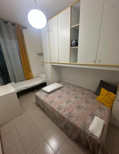 una piccola stanza con un letto e un armadio di Valentin Monfalcone Apartment near Fincantieri and Marina Julia a Monfalcone