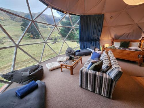 LivingstoneにあるDanseys Pass Lavender Farm Retreatの大きなテントの中にソファのあるリビングルーム