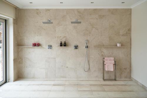 a bathroom with a shower with a tiled wall at Château Boussas in Couloumé-Mondébat