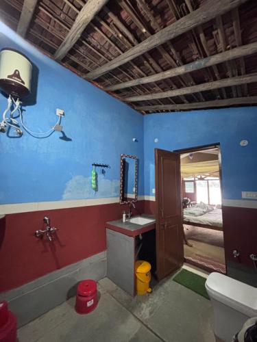 MaheshwarにあるKirti kewat Homestayのバスルーム(洗面台、トイレ付)、ベッド1台が備わります。