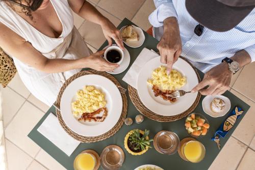 a group of people sitting around a table eating food at Dolcevita Cliff Resort Dieppe bay by KlabHouse in Falmouth